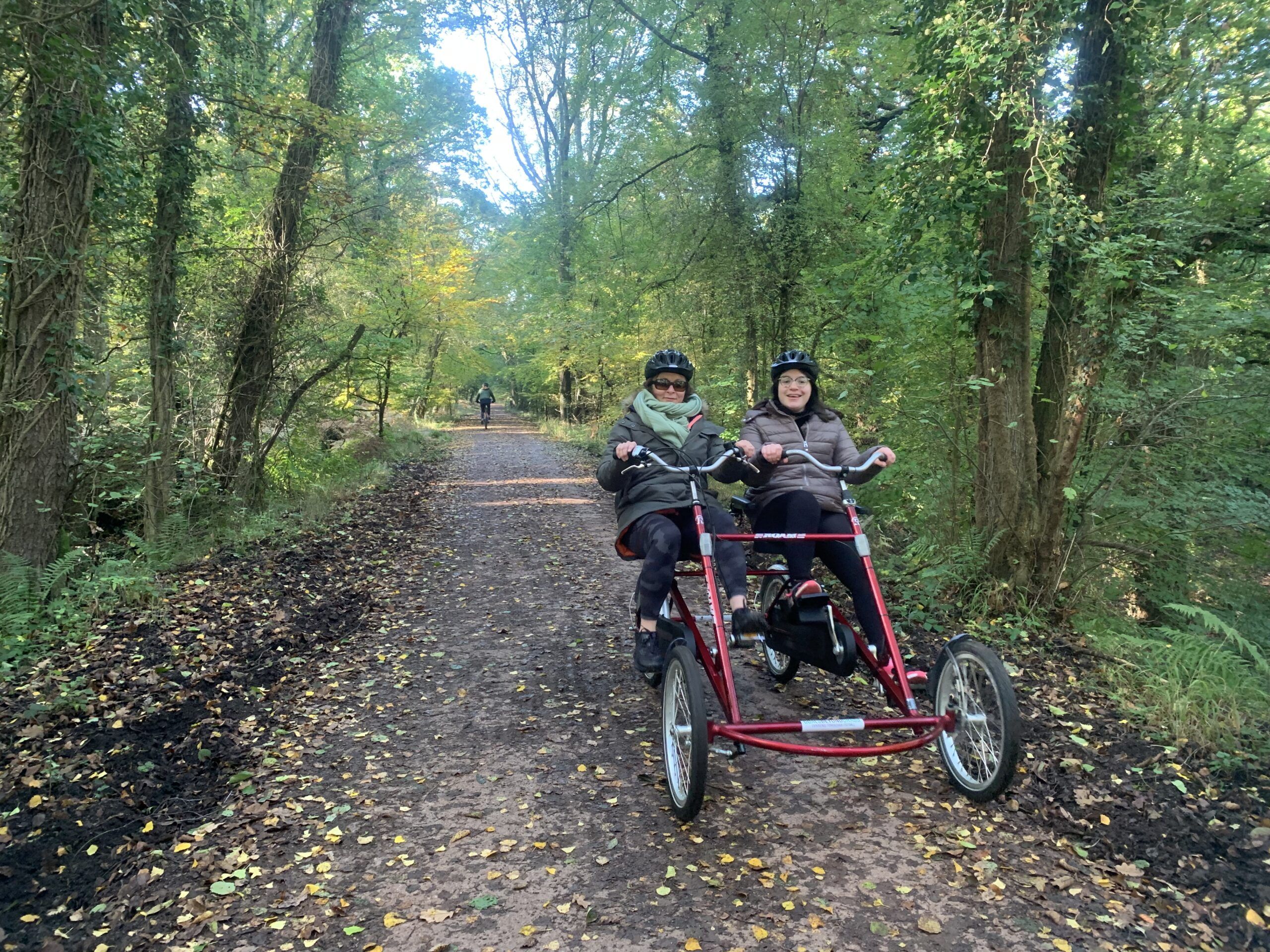 A volunteer cycling through the Forest of Dean with her carer